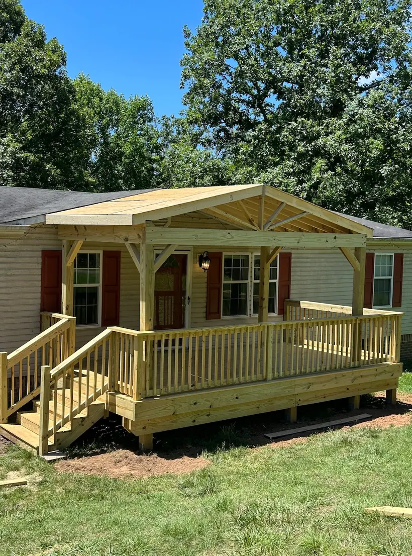 New custom covered front porch with gable roof and pressure-treated deck after build in Taylorsville NC — The Foothills Deck Company