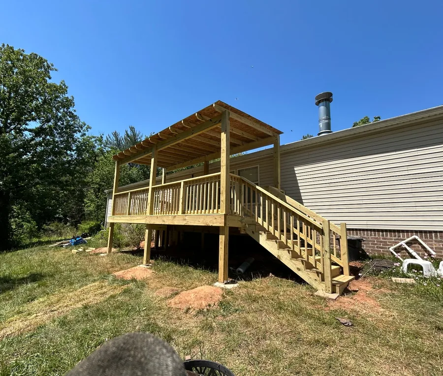 New elevated pressure-treated wood deck with pergola and staircase after rebuild in Taylorsville NC — The Foothills Deck Company