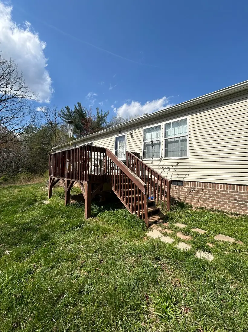 Old weathered back deck with failing stairs before rebuild in Taylorsville NC — The Foothills Deck Company